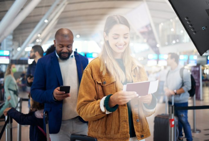 A woman is listening to a directional speaker giving instruction to prepare her passport.